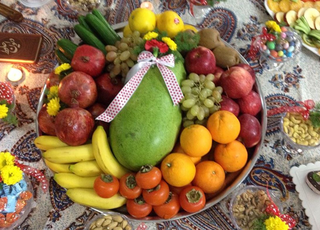 A Yalda table of pomegranates, watermelon and fruit.